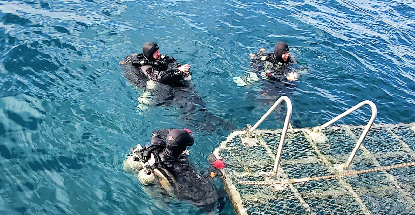 Technical divers in the water beside the boat, Truk Lagoon